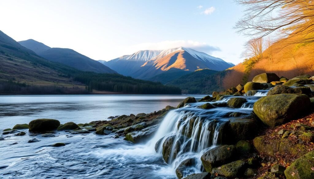 Killarney National Park, a breathtaking natural wonder in the heart of Ireland. A serene landscape of rolling hills, crystal-clear lakes, and cascading waterfalls, bathed in soft, golden light. In the foreground, a picturesque waterfall tumbles over moss-covered rocks, its mist gently drifting through the air. The middle ground features a tranquil lake, its still surface reflecting the surrounding mountains and verdant forests. In the background, towering peaks reach towards the sky, their snow-capped summits kissed by wispy clouds. The scene exudes a sense of peace and timeless beauty, inviting the viewer to immerse themselves in the unspoiled splendor of this Irish gem.